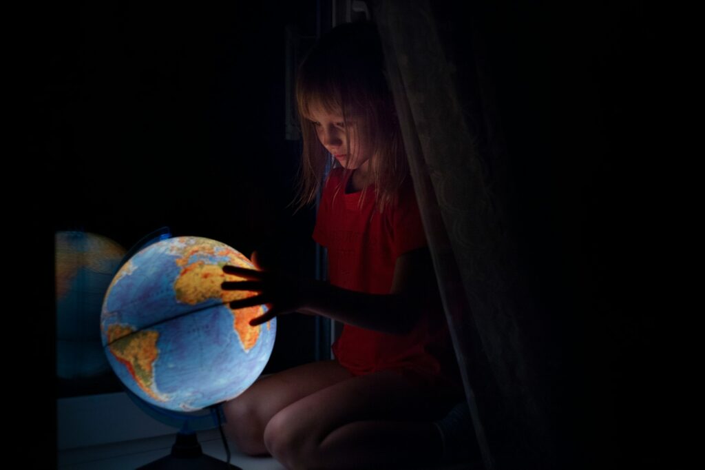 A girl looking at a globe.